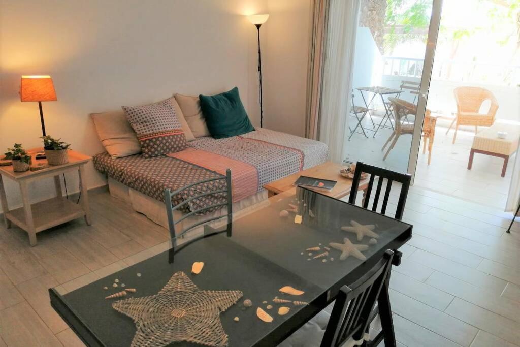 een woonkamer met een bank en een tafel bij Comfortable Cleo apartment with large terrace in Costa Teguise