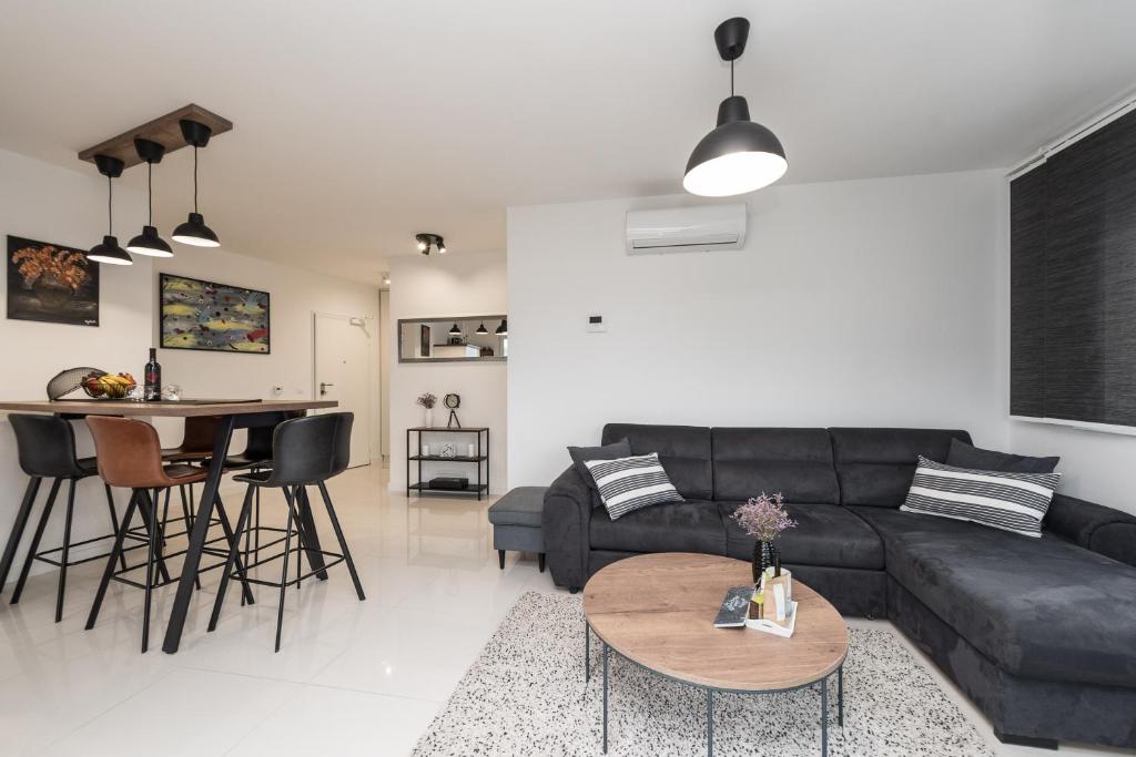 a living room with a black couch and a table at Apartman Enjoy Nin in Nin