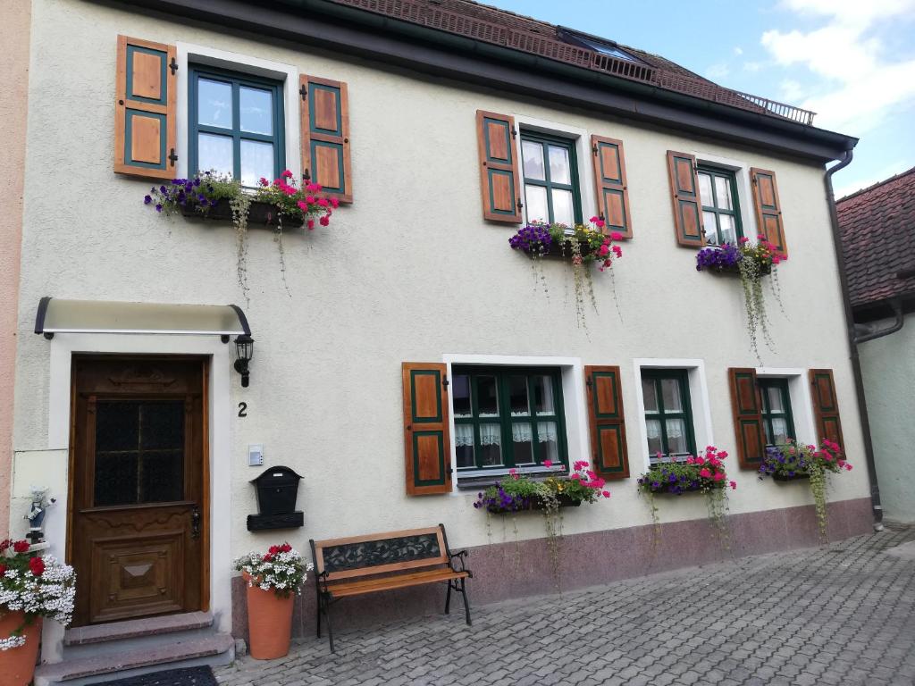 a white building with windows and flower boxes at Ochsenhof in Feuchtwangen