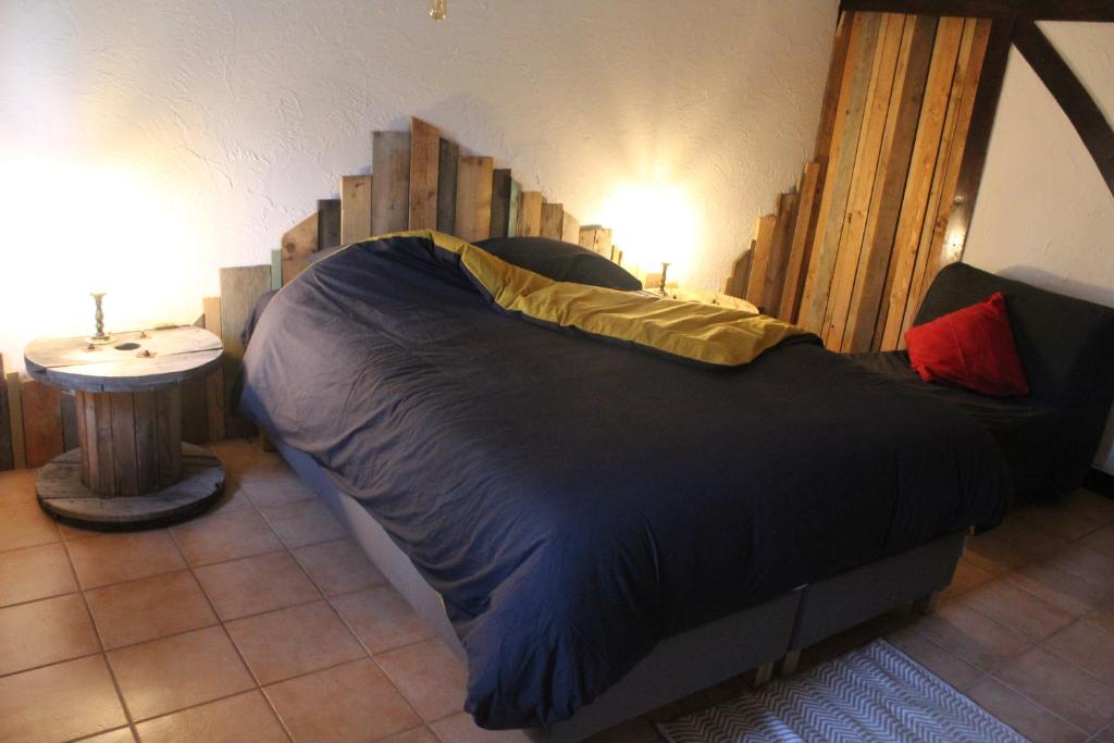 a bedroom with a large bed with a wooden headboard at Bois & Repos in Malmedy
