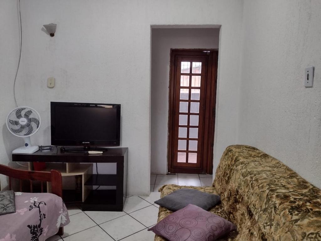 CASA NA PRAIA TEMPORADA في بيرويبي: غرفة معيشة بها أريكة وتلفزيون