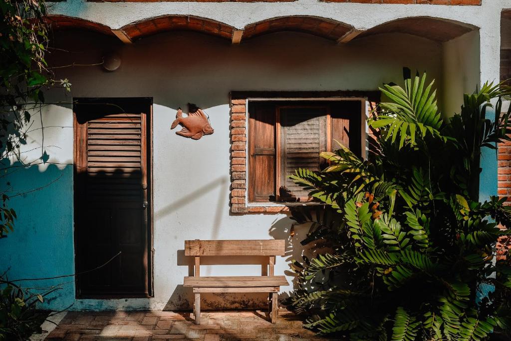 a bench sitting outside of a house with a window at Hosteria Chata Adults Only in Lo de Marcos