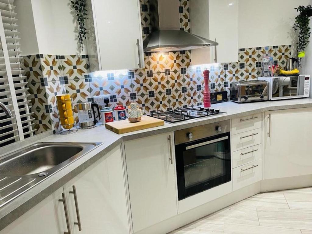 a kitchen with a sink and a stove top oven at Bagshot PennyHill Park Camberley Ascot Luxury 1 Bed 1 Bath Sleeps 4 in Bagshot