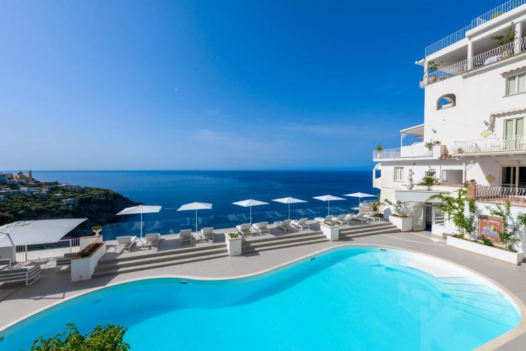 a pool in front of a building with a view of the ocean at Grand Hotel Tritone in Praiano