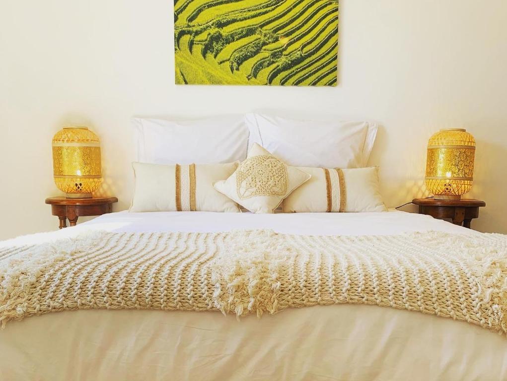 a bedroom with a large white bed with two lamps at Le Petit Bali Spacieuse Villa pour 8 avec Piscine in Saint Cyprien Plage