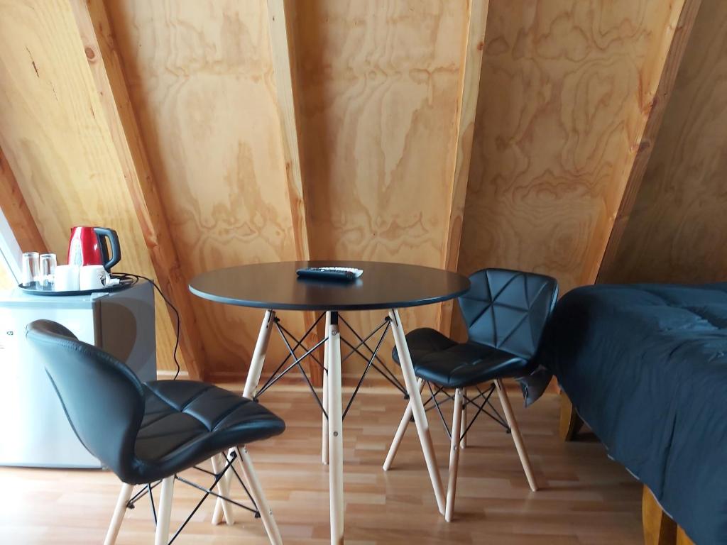 een kleine tafel en 2 stoelen in een kamer bij A-FRAME CABIN PUCON in Pucón
