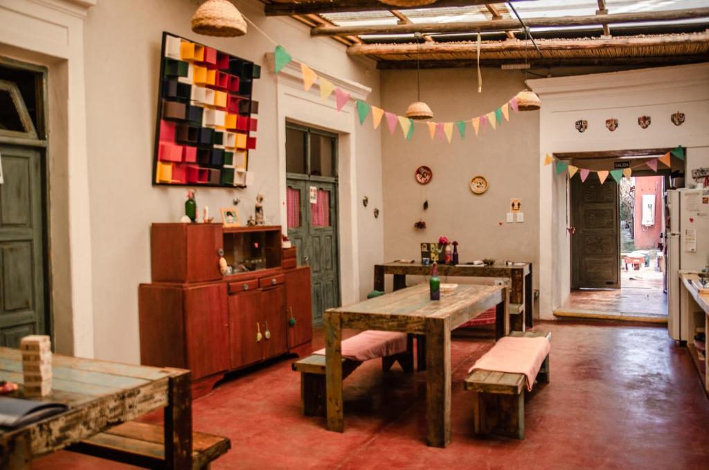 a room with a table and benches and a room with flags at Cielito Lindo in Cafayate