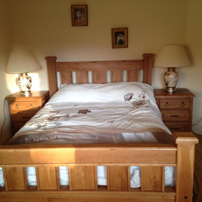 una camera con letto in legno e 2 comodini di Golf Course View a Kenmare