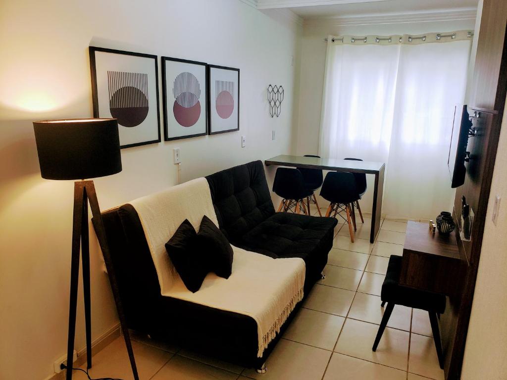 uma sala de estar com um sofá e uma mesa em Residencial Catarina em Florianópolis