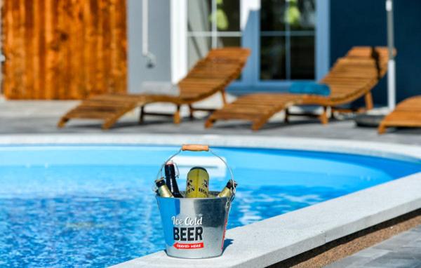 a can of beer sitting next to a swimming pool at Kuća za odmor - Sanjalica in Sračinec