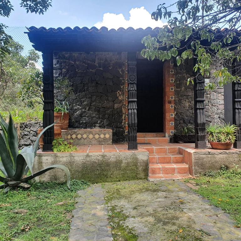 ein Steinhaus mit einer Veranda und einem Eingang in der Unterkunft cozy mini loft near COLMEX FLACSO in Mexiko-Stadt