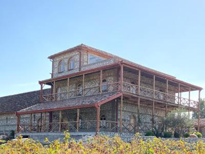 un gran edificio de madera con balcones en la parte superior. en Elizbar Talakvadze Winery en Kardanakhi