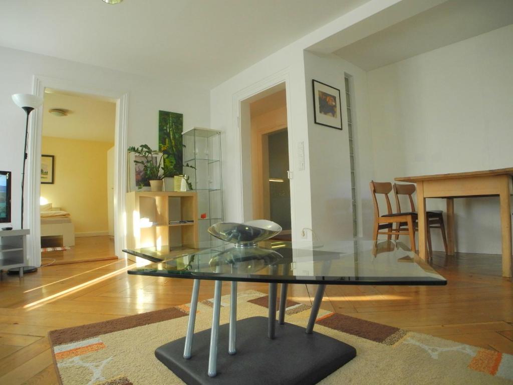ein Wohnzimmer mit einem Glastisch in einem Zimmer in der Unterkunft Appartements Katharinenhof in Dornbirn