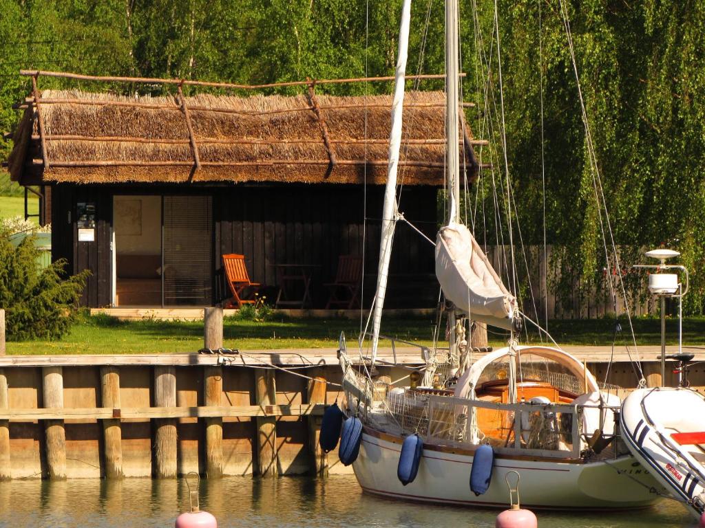 Ein Boot liegt an einer Anlegestelle mit einem Haus. in der Unterkunft Peterzens Boathouse in Laupunen
