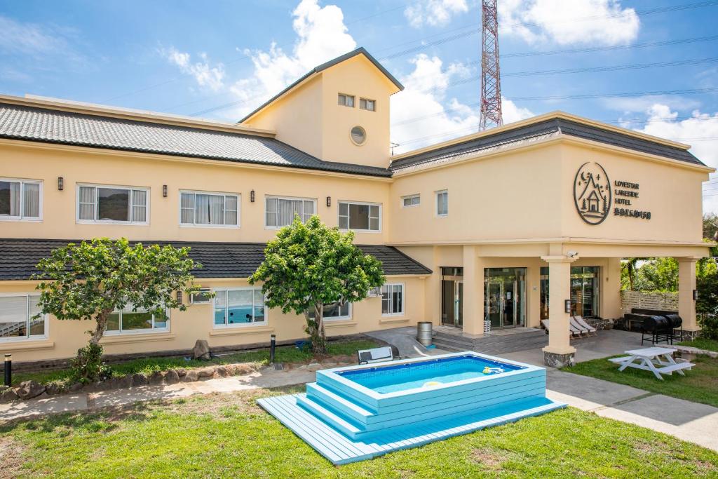 a house with a swimming pool in front of it at Lovestar Lakeside Hotel - Stars Building in Nanwan