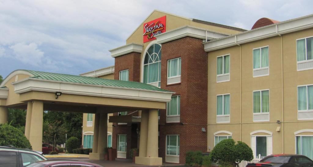 a hotel with a sign on the front of it at Stay Inn & Suites Montgomery in Montgomery