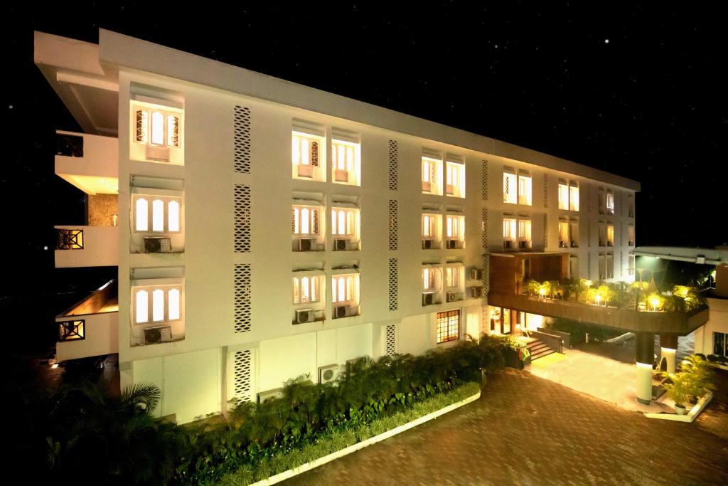 a large white building at night with lights at The Cindrella Hotel in Siliguri