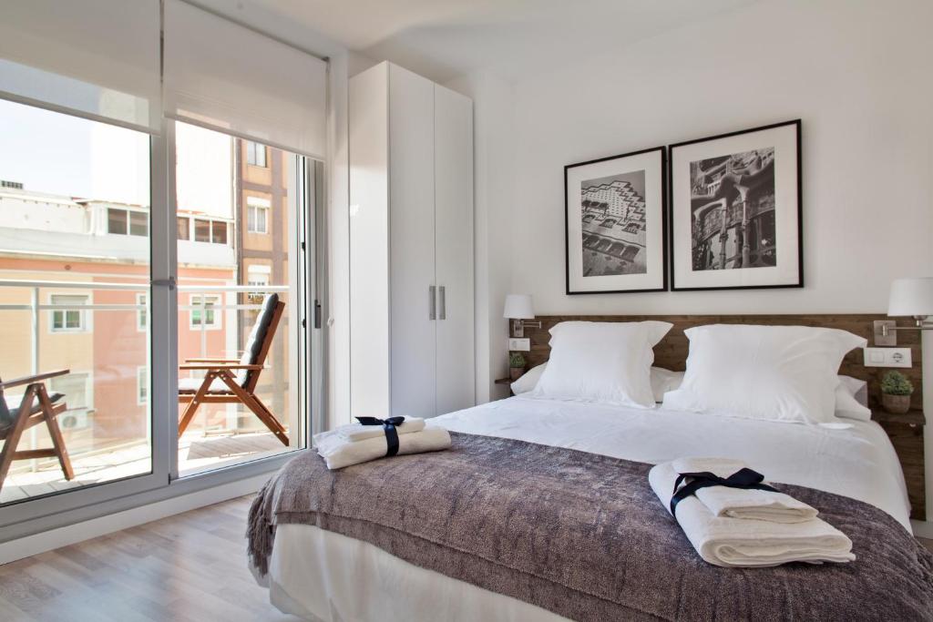 a bedroom with a large bed and a large window at Habitat Apartments Blanca in Barcelona