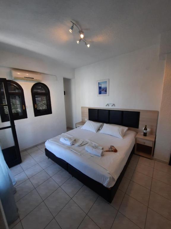 a bedroom with a large bed with two towels on it at Tassos 2 in Pefkohori