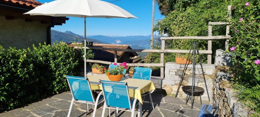 - une table et des chaises avec un parasol sur la terrasse dans l'établissement Casa al Sasso, à Bedigliora
