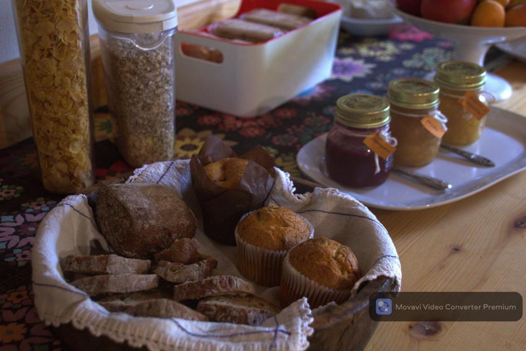 a table with a basket of muffins and jars of jam at Casa Acquariana in Belluno
