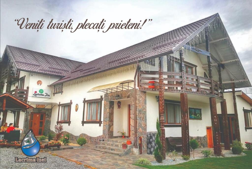 a house with a porch and a balcony at Lacrima Izei in Săcel