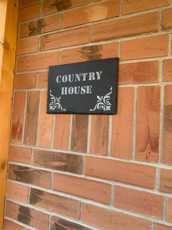 a sign for a county house on a brick wall at Country house in Svidník