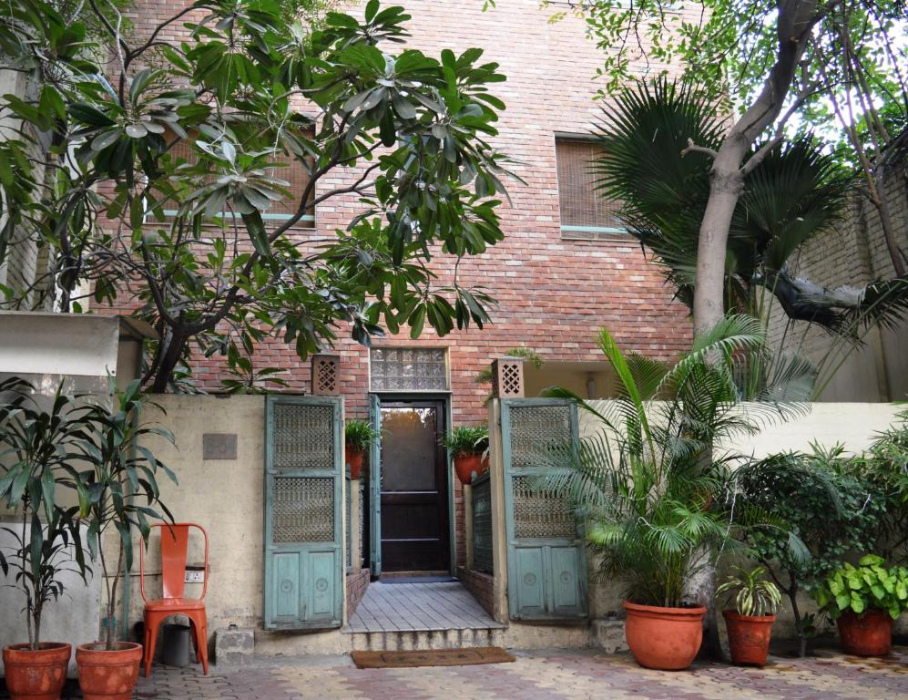 an open door of a brick building with a red chair at Zaza Stay in New Delhi