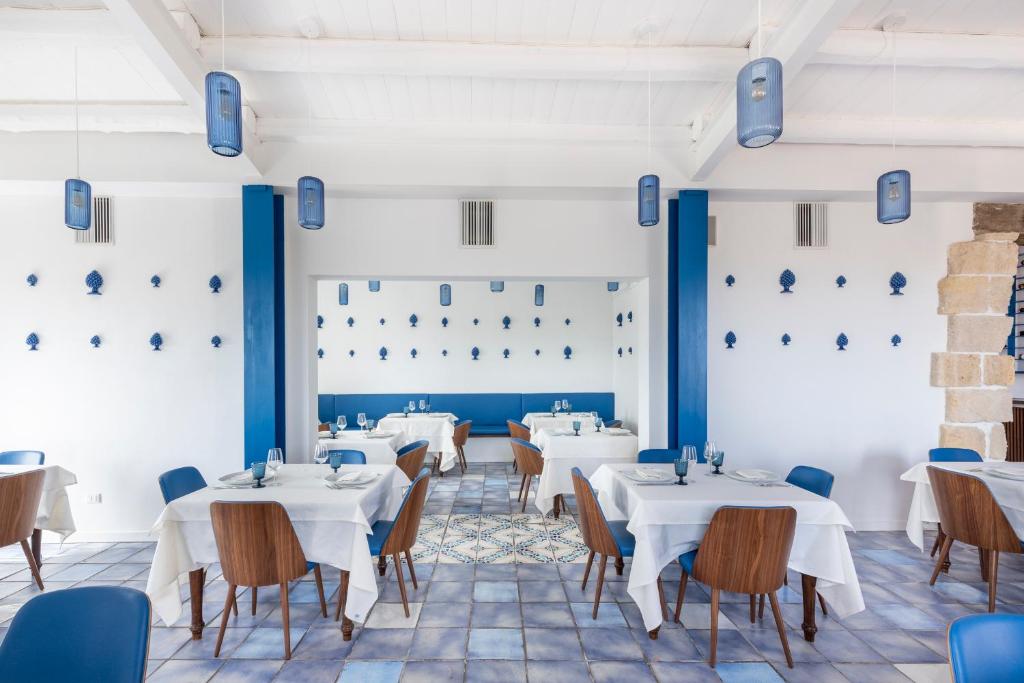 a dining room with white tables and chairs at Hotel La Corte Del Sole in Noto