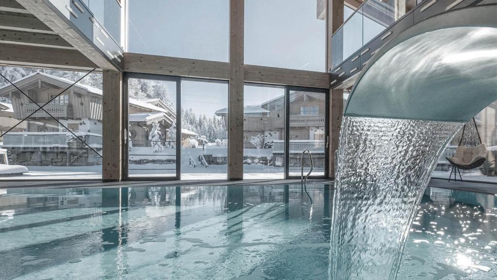 a swimming pool with a water fountain in a building at INNs HOLZ in Ulrichsberg