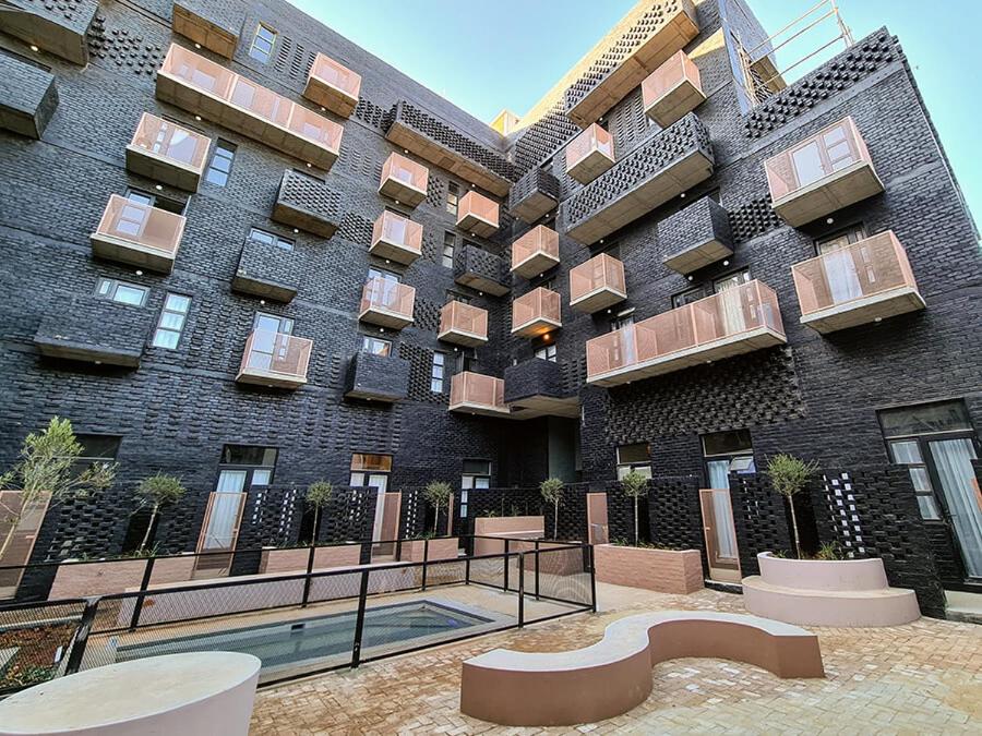 a large brick building with a pool in front of it at Maboneng City Building Free WiFi and Swimming pool in Johannesburg