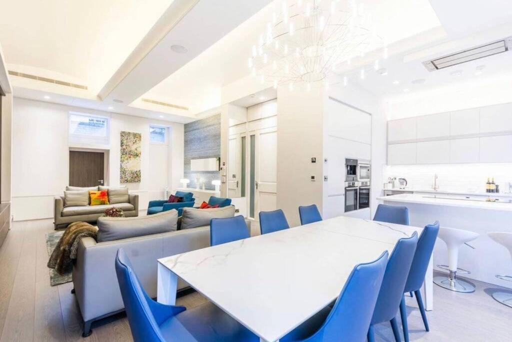 a dining room with a white table and blue chairs at Superb Apartment near Buckingham Palace in London