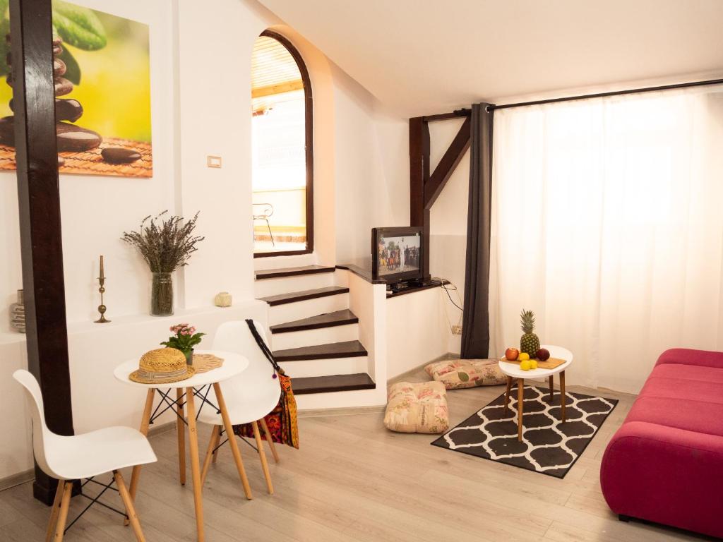 a living room with a red couch and a table at One Love Terrace Apartment in Bucharest