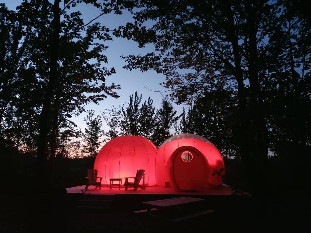 Pointe-du-Chêne的住宿－Maplebrook Retreat，两个红色的圆顶,椅子坐在他们前面