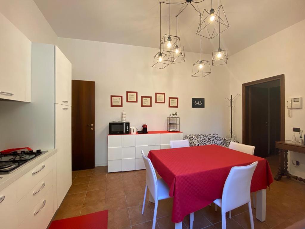 una cucina e una sala da pranzo con tavolo e sedie rossi di 6.4.6 - Via Jodi 6 a Reggio Emilia