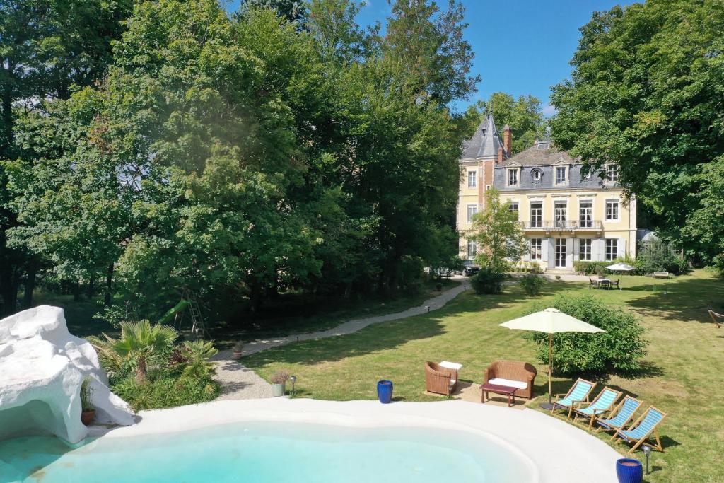 uma grande piscina em frente a uma casa em Château de Corcelle - Chambres et table d'hôtes em Châtenoy-le-Royal