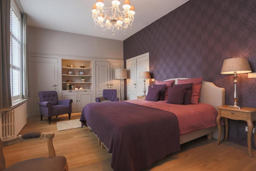 a hotel room with a bed, chair, table and lamp at B&B De Bornedrager in Bruges