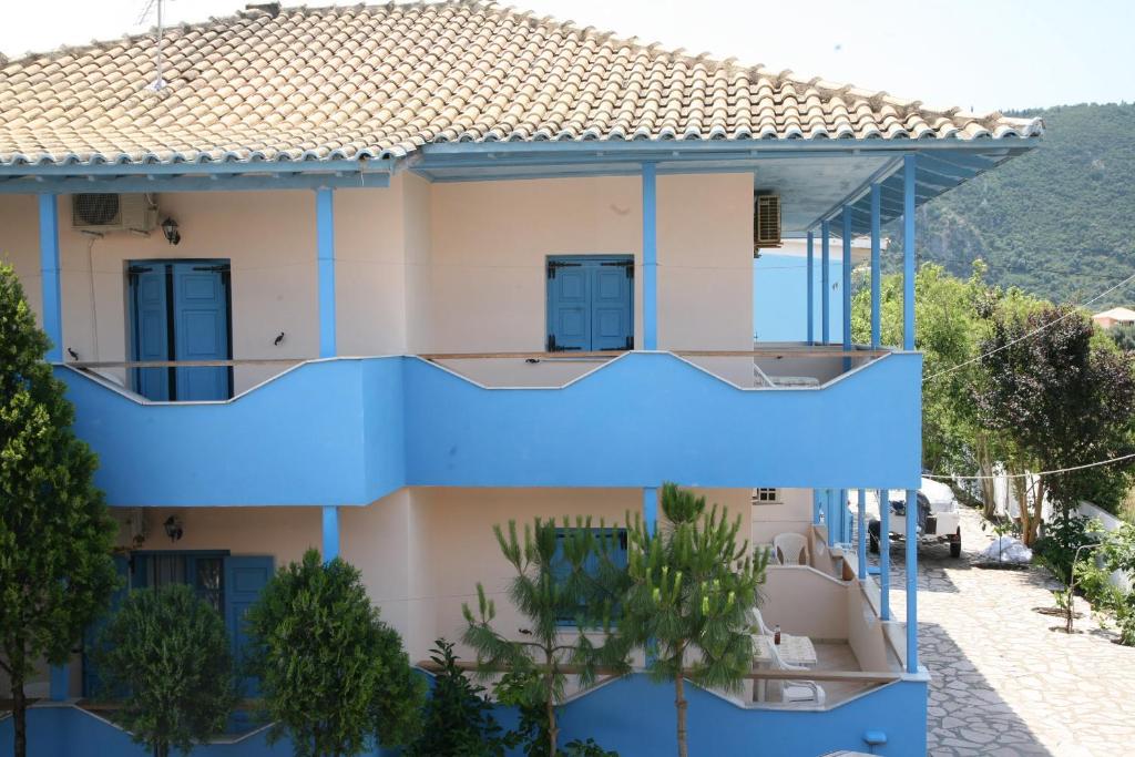 Casa azul con balcón y árboles en Pension Maria en Lefkada