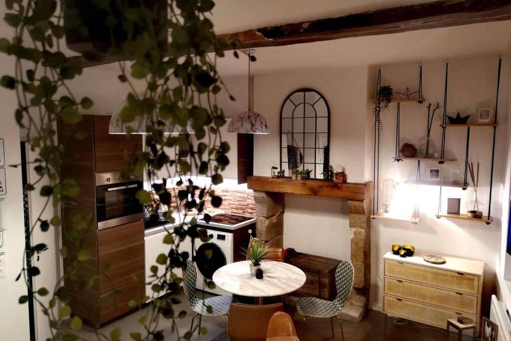 een keuken met een tafel in het midden van een kamer bij Le repaire malouin in Saint-Malo