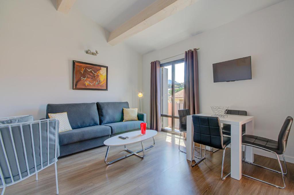 - un salon avec un canapé bleu et une table dans l'établissement Le 15-Appartments Collioure, à Collioure