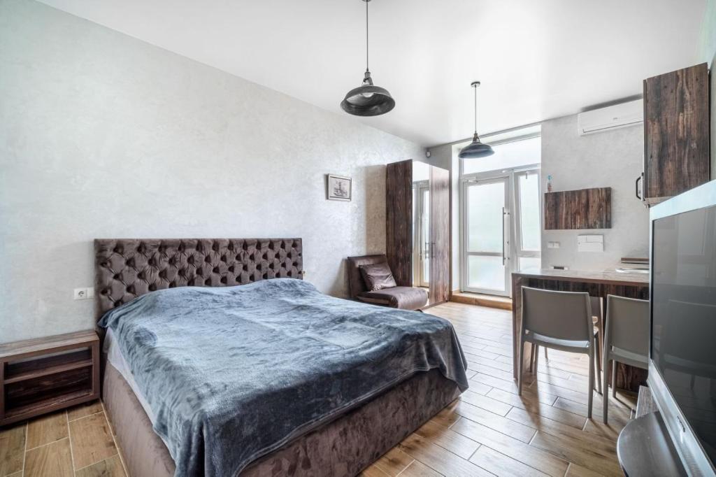 a bedroom with a large bed and a kitchen at Boomerang apart-apart hotel in Kolomiya