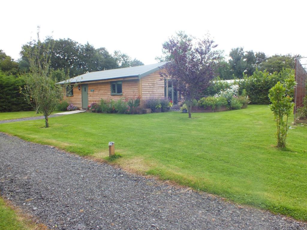a house with a grass yard with a house at The Potting Shed And The Garden Shed Self Catering in Carmarthen