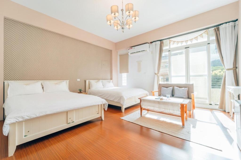 a bedroom with two beds and a chandelier at Moonlit Corner in Taitung City