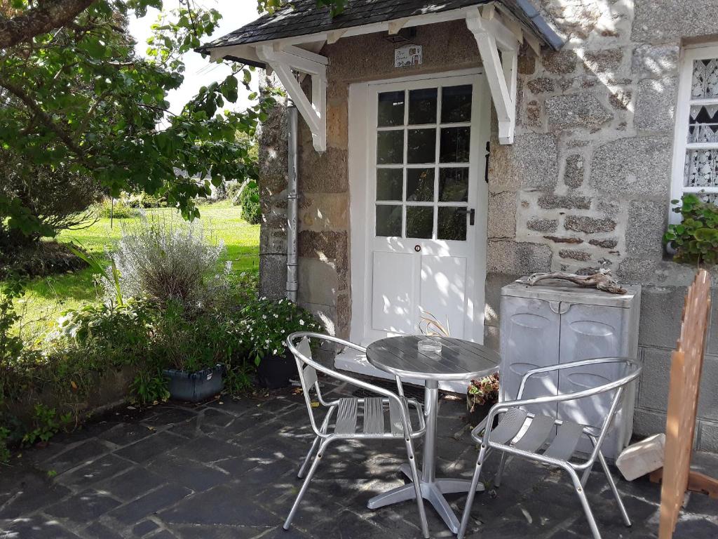 une terrasse avec une table et des chaises devant une maison dans l'établissement Ker Jerome - Traditional Stone Breton Cottage near to Dinan, à Trélivan