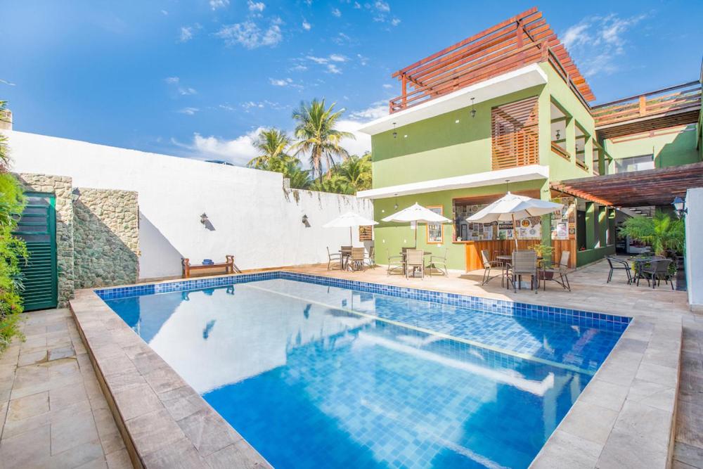 uma piscina em frente a uma casa em Hotel Cajueiro Guarujá no Guarujá