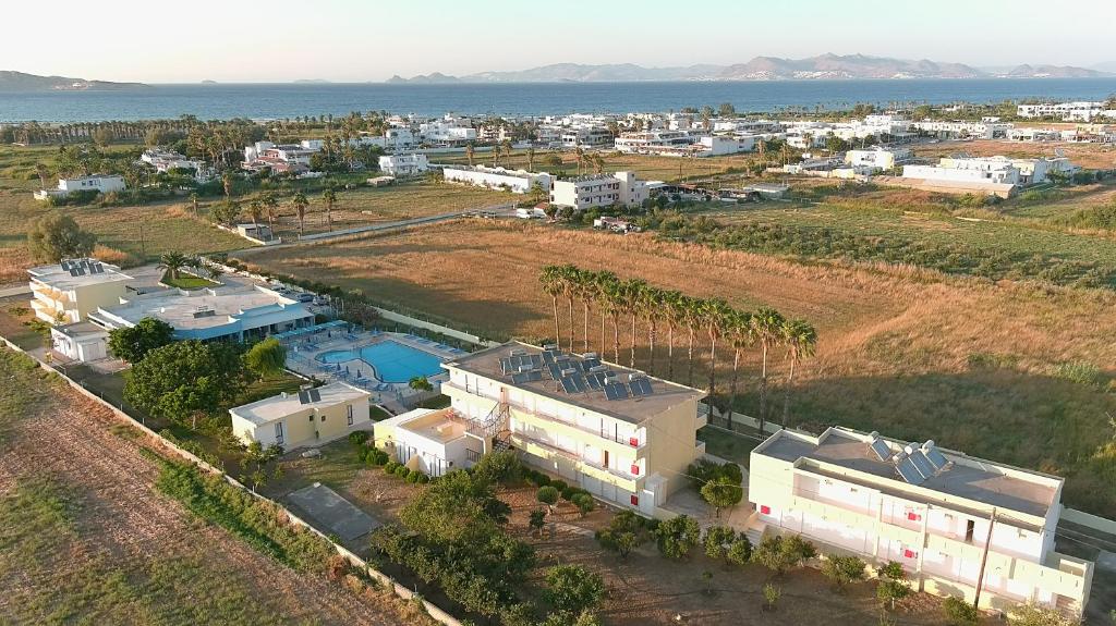 eine Luftansicht einer Stadt mit Gebäuden und dem Meer in der Unterkunft Oasis Tigaki in Tigaki