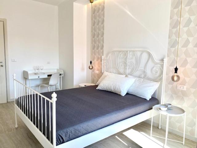 a bedroom with a white bed and a desk at Le Calette House - Puglia Mia Apartments in Monopoli