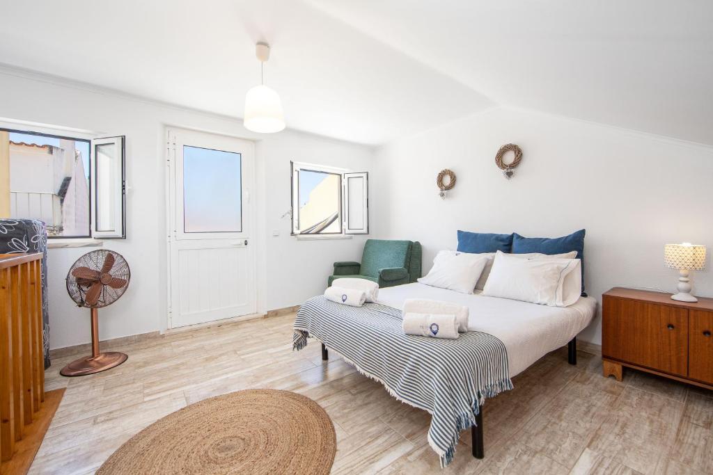 een slaapkamer met een bed en een tafel met een ventilator bij Caparica Beach Apartment by HOST-POINT in Costa da Caparica