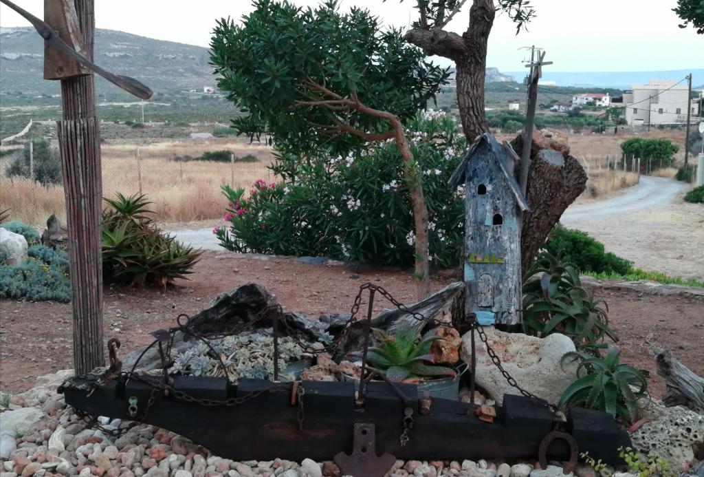 a bird house sitting in a garden at Domatia me Thea in Elafonisos