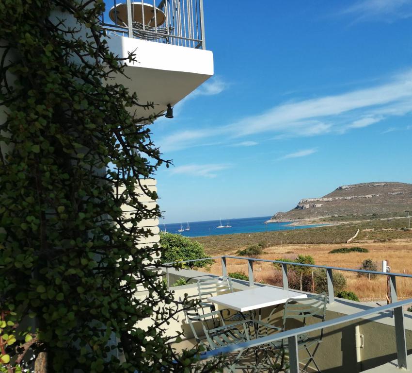 a balcony with a table and chairs and the ocean at Domatia me Thea in Elafonisos